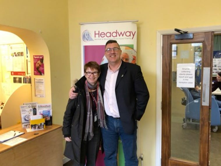 Mike with unknown person standing in front of a Headway Banner